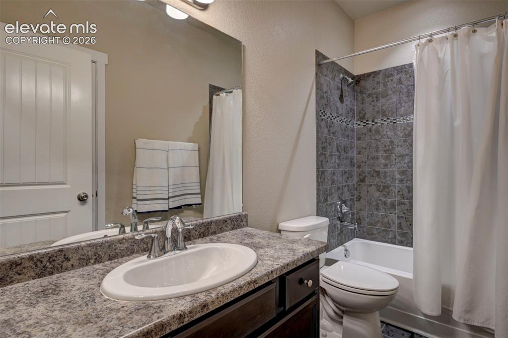 Image 36 of 40: Bathroom featuring a vanity with an integrated sink, a speckled countertop,