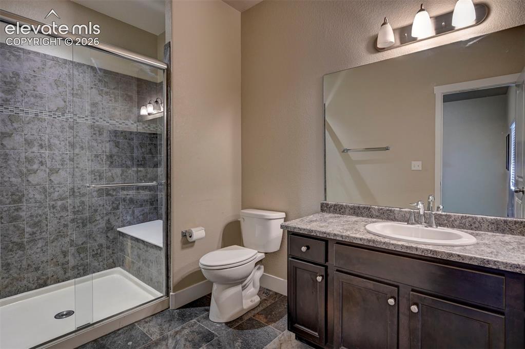 Image 39 of 40: Shower with tiled surround, glass enclosure, and built-in bench