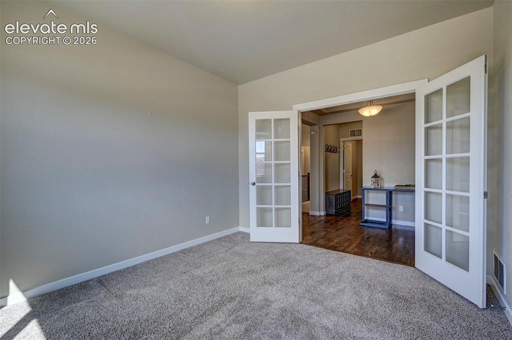 Image 7 of 40: Recessed entry with double French doors and frosted glass panels opening to