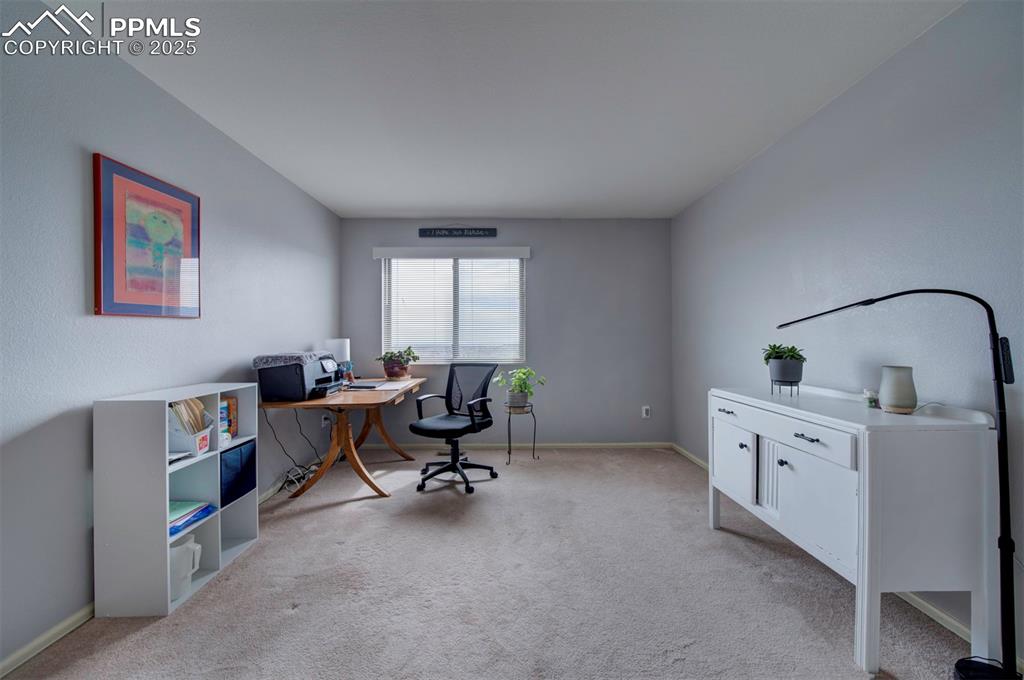 Image 26 of 50: Office space with baseboards and light colored carpet