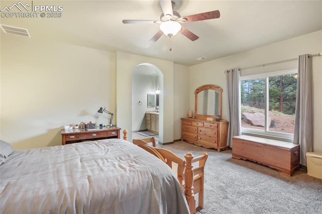 Image 12 of 33: The main bedroom has plenty of natural light with an arched walkway into an