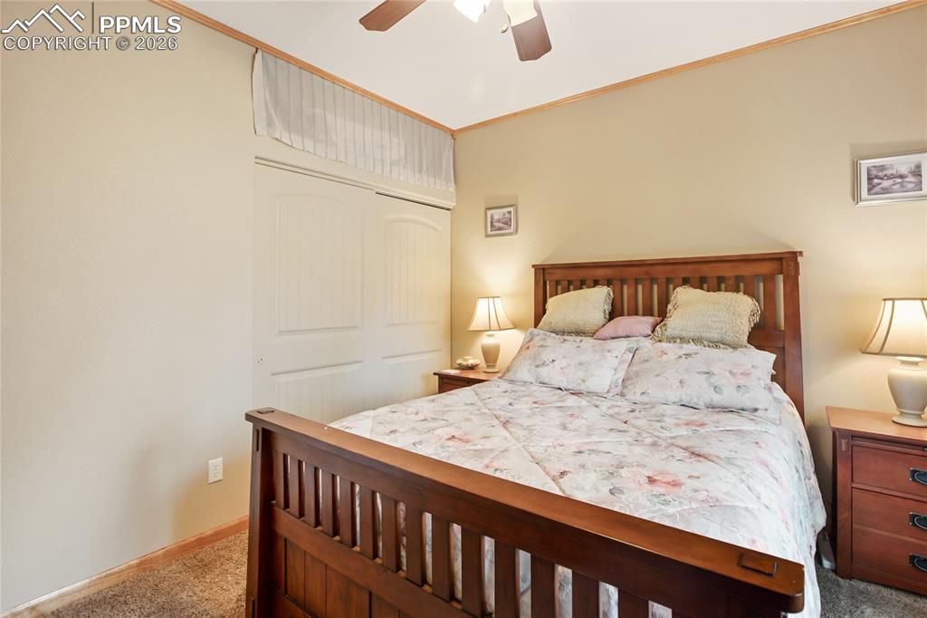 Image 16 of 33: The bedroom with crown molding, a closet, and ceiling fan!
