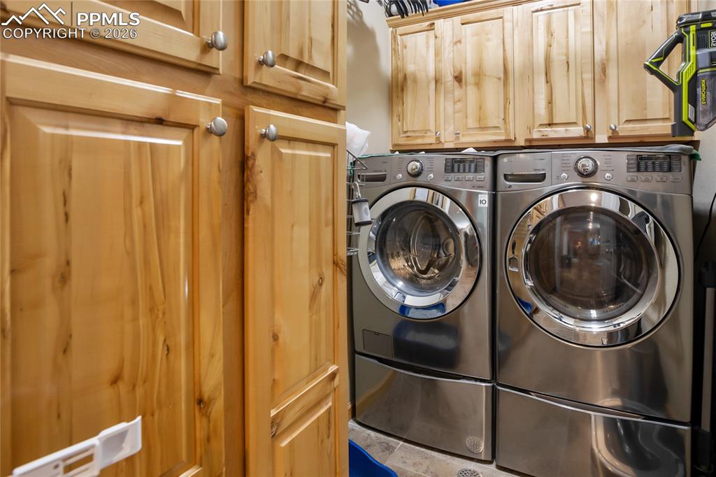 Image 18 of 33: A laundry space with plenty of pine cabinets for storage!