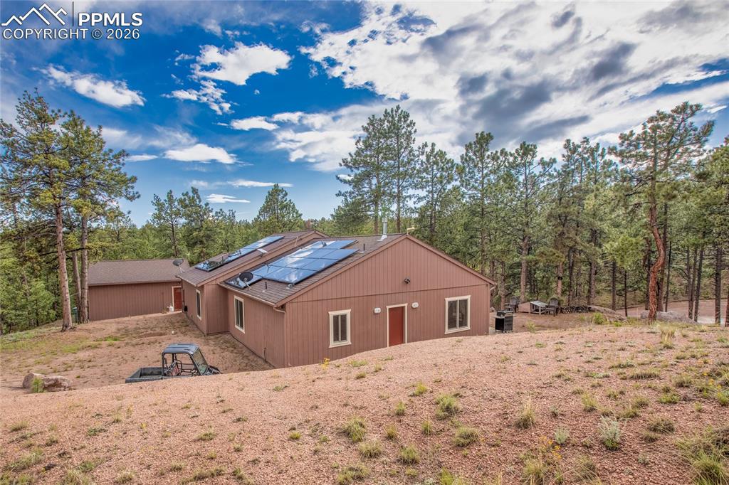 Image 21 of 33: The side of the house featuring roof mounted solar panels!