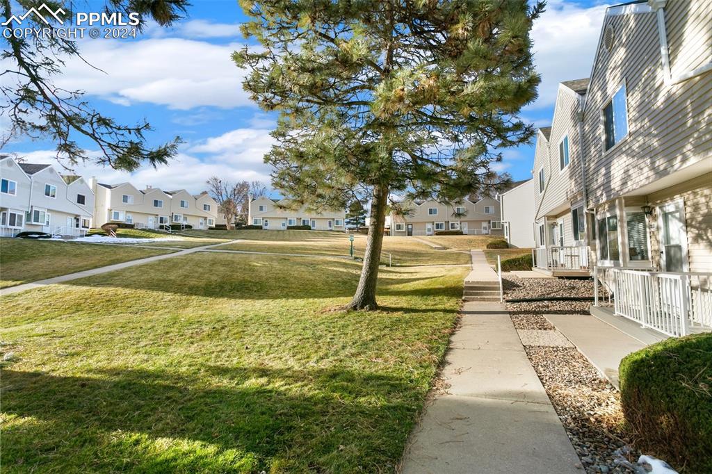 Image 3 of 26: Surrounding community with a lawn