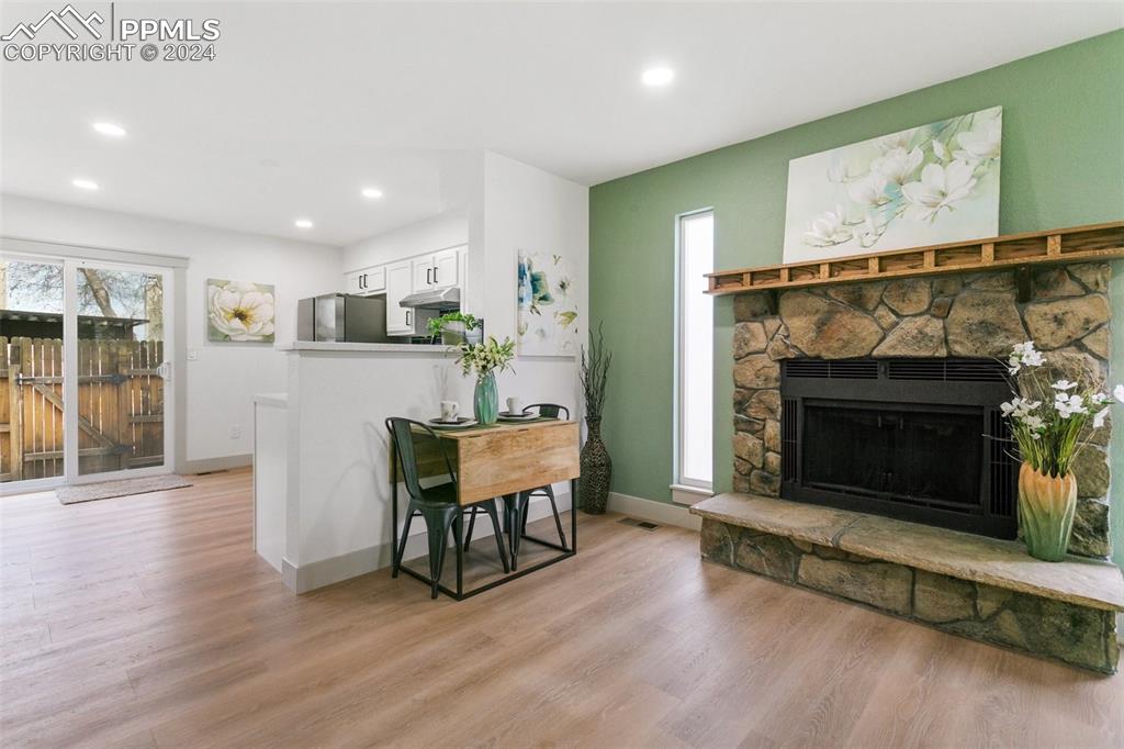 Image 9 of 26: Living room featuring light hardwood / wood-style floors and a stone firepl