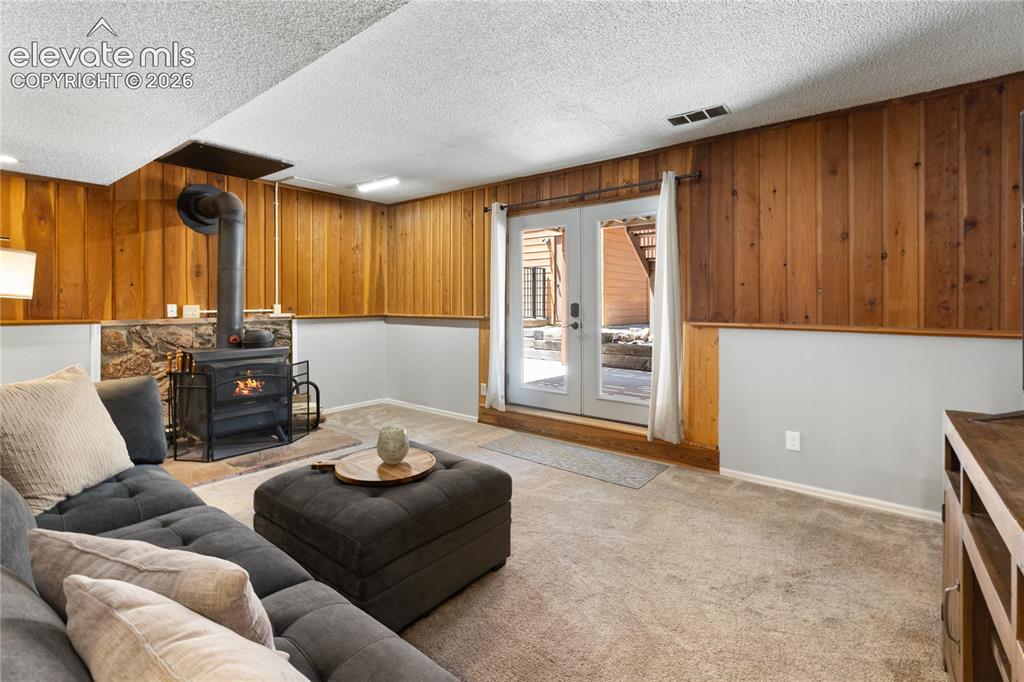 Image 19 of 27: What a great family room with a wood burning stove!