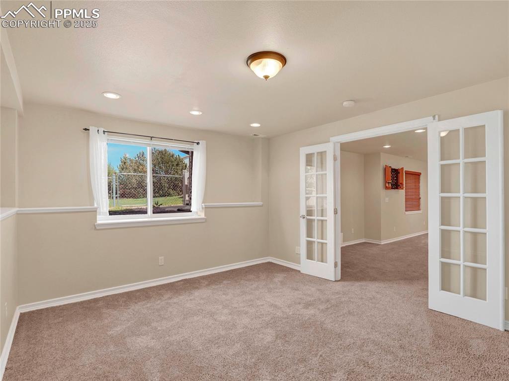Image 27 of 45: Basement Bedroom with Large Walk in Closet and French Doors