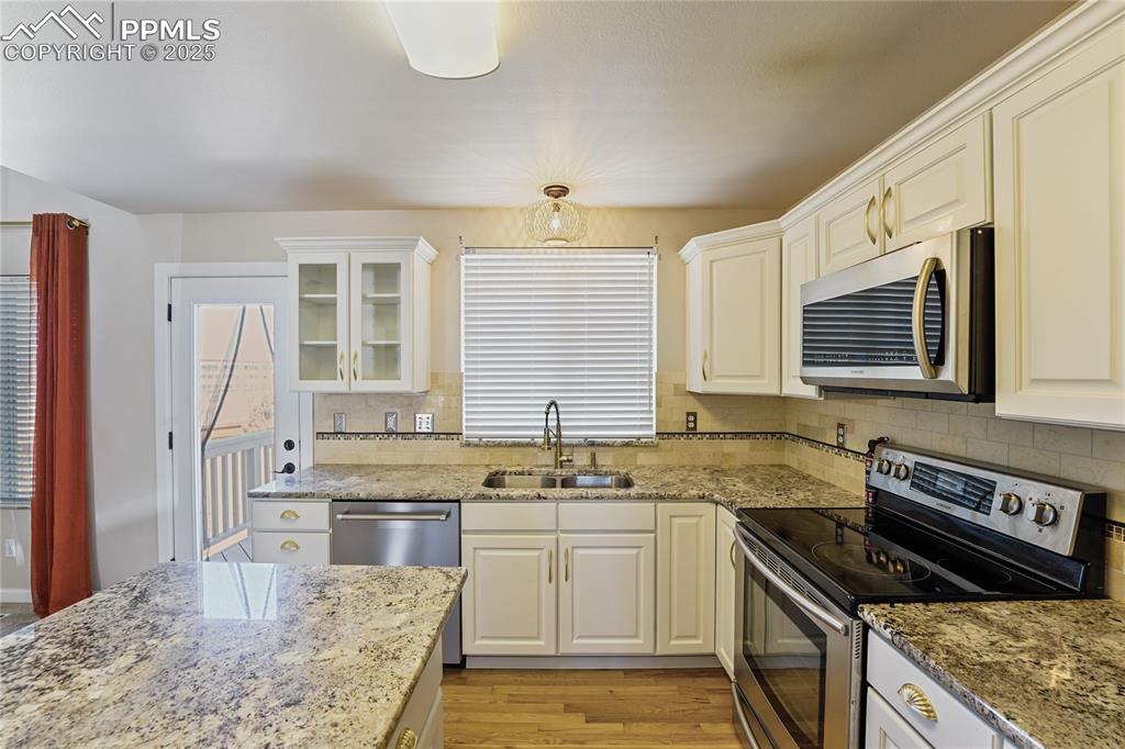 Image 9 of 45: Granite Countertops, Stainless Steel Appliances. Window Over Sink Views Bac