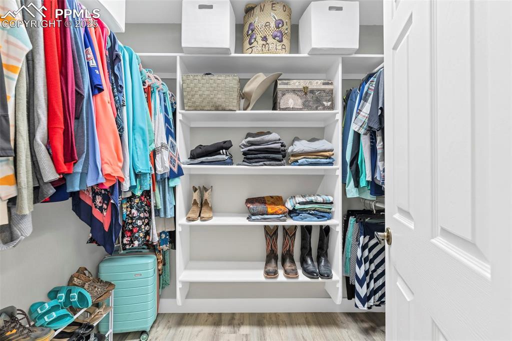 Image 13 of 50: The suite includes a spacious walk-in closet with plenty of shelving to org