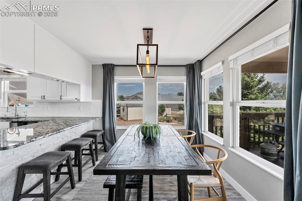 Image 22 of 50: The dining area is surrounded by windows and overlooks the mountains and pr