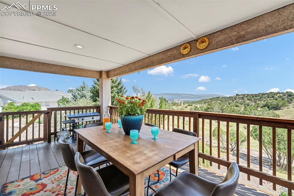 Image 5 of 50: The extensive covered deck has a staircase to the rear patio and back yard.