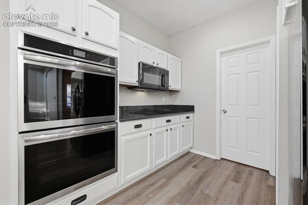 Image 18 of 44: Spacious pantry and half bath are tucked back in the kitchen 