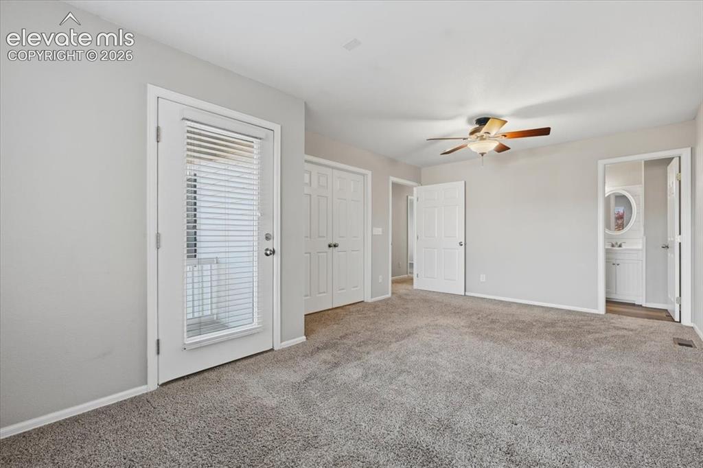 Image 22 of 44: Carpeted flooring, ceiling fan, white paneled doors, and a glass-paneled ex