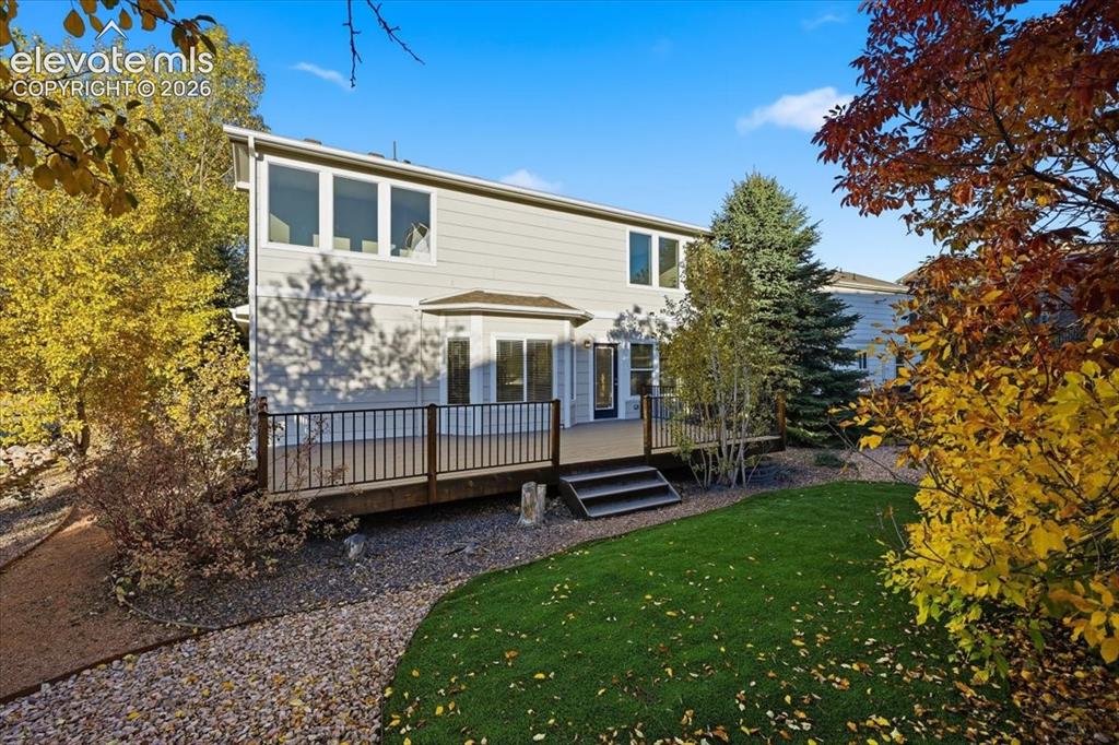 Image 3 of 44: Large trex deck with turf and mature landscaping 
