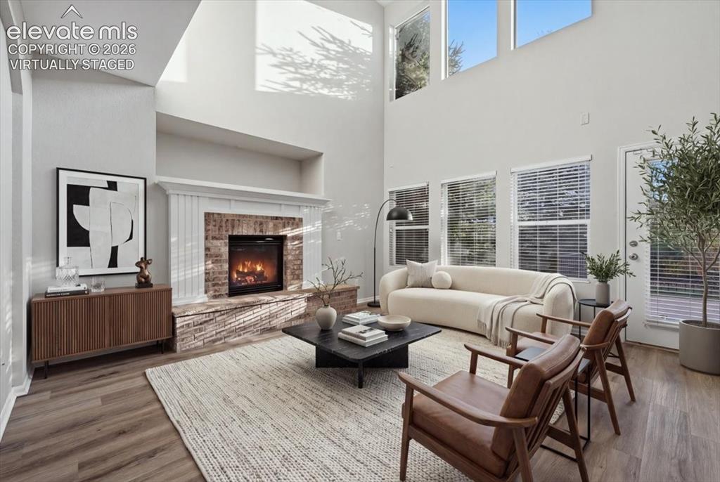 Image 6 of 44: tall ceilings gas fireplace and large windows. Virtually staged