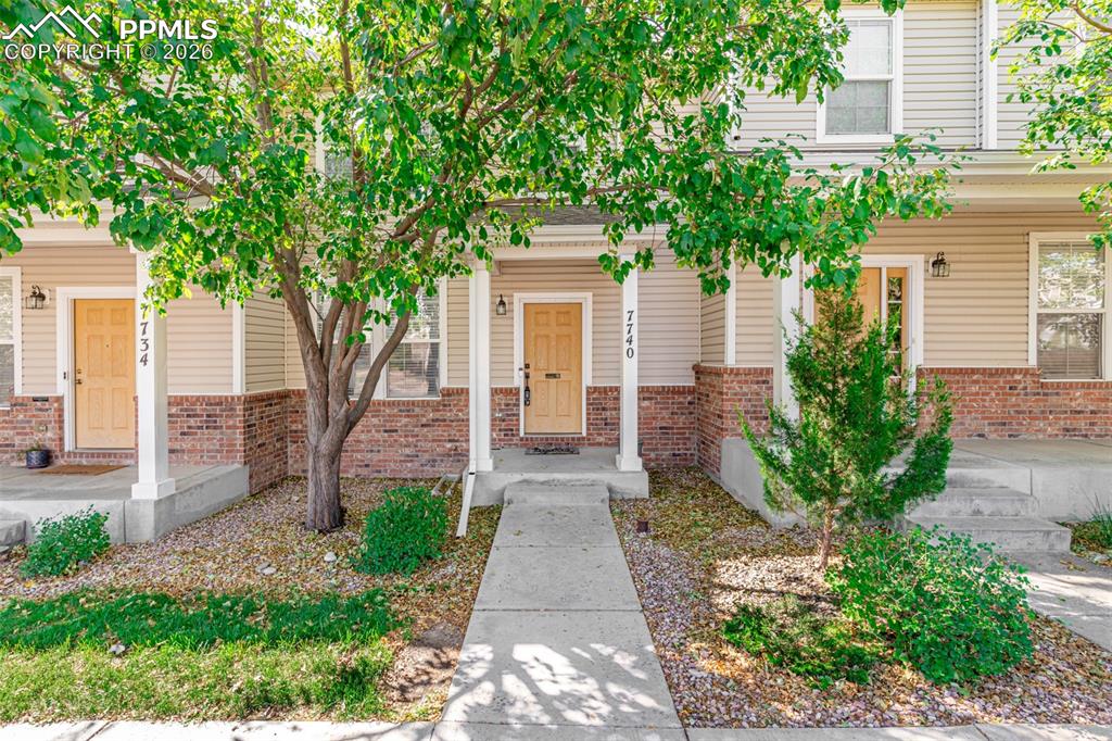 Image 1 of 34: Inviting covered porch/Doorway to property featuring brick siding