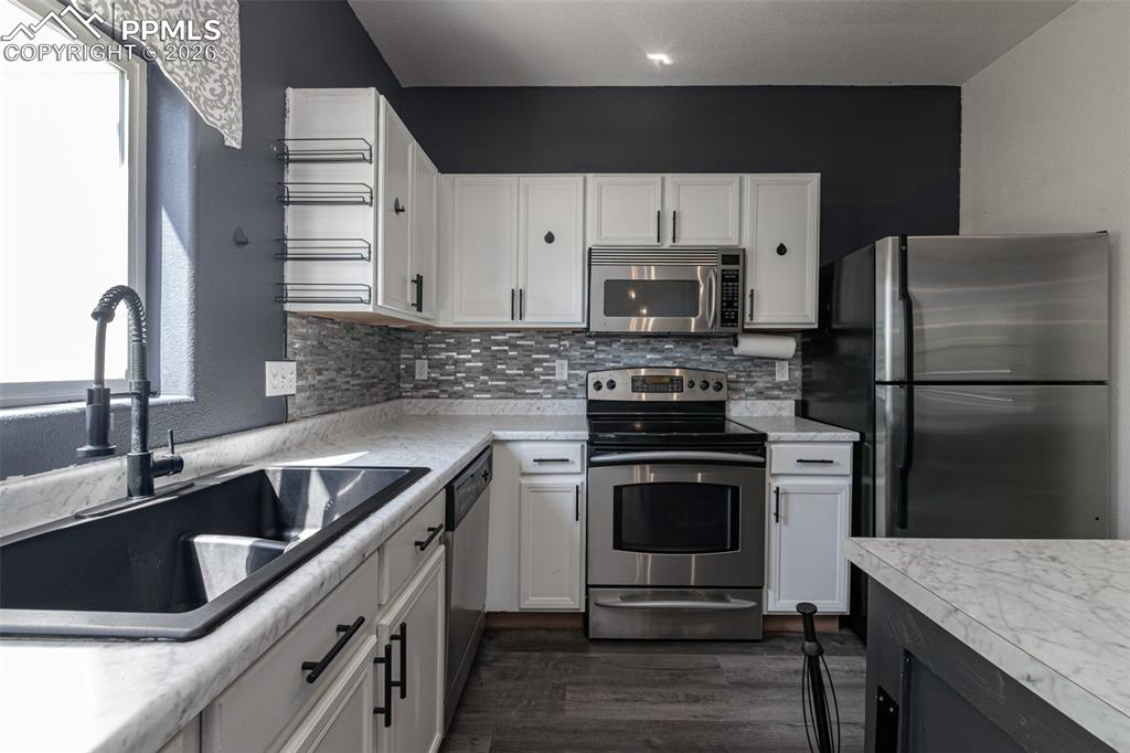 Image 12 of 34: Two tone kitchen featuring two tone cabinetry, stainless steel appliances, 