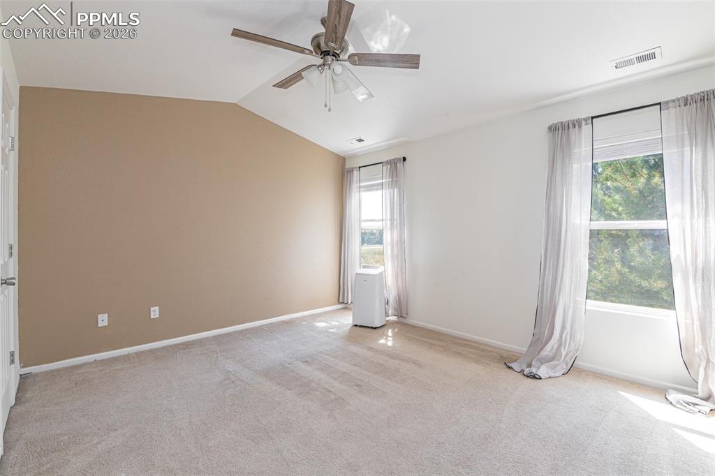 Image 18 of 34: Spare room with ceiling fan, light carpet, and vaulted ceiling