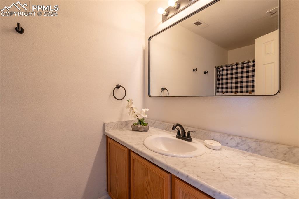 Image 20 of 34: Full bath with vanity and curtained shower