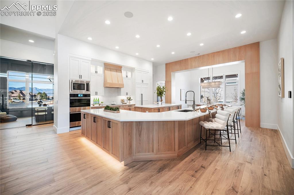 Image 3 of 43: Custom white oak cabinetry anchors the kitchen, paired with a high-end Jenn