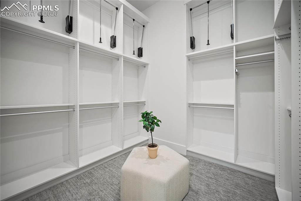 Image 30 of 43: Large master closet with built-in cabinets and lots of storage.