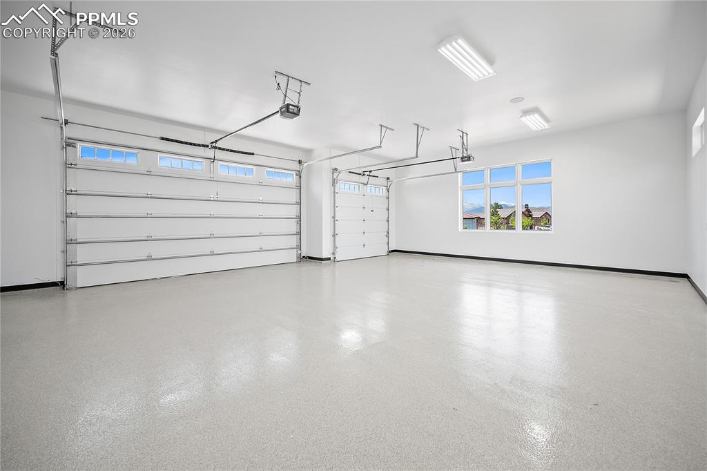 Image 38 of 43: An oversized three-car garage that is fully drywalled and insulated, featur