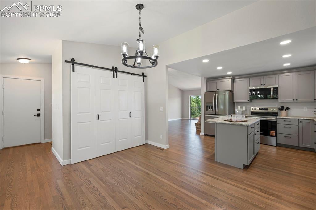 Image 10 of 48: Kitchen with appliances with stainless steel finishes, gray cabinetry, a ba