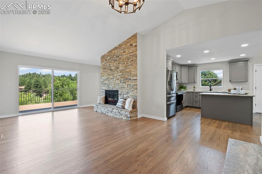Image 2 of 48: Living room featuring high vaulted ceiling, a chandelier, wood finished flo