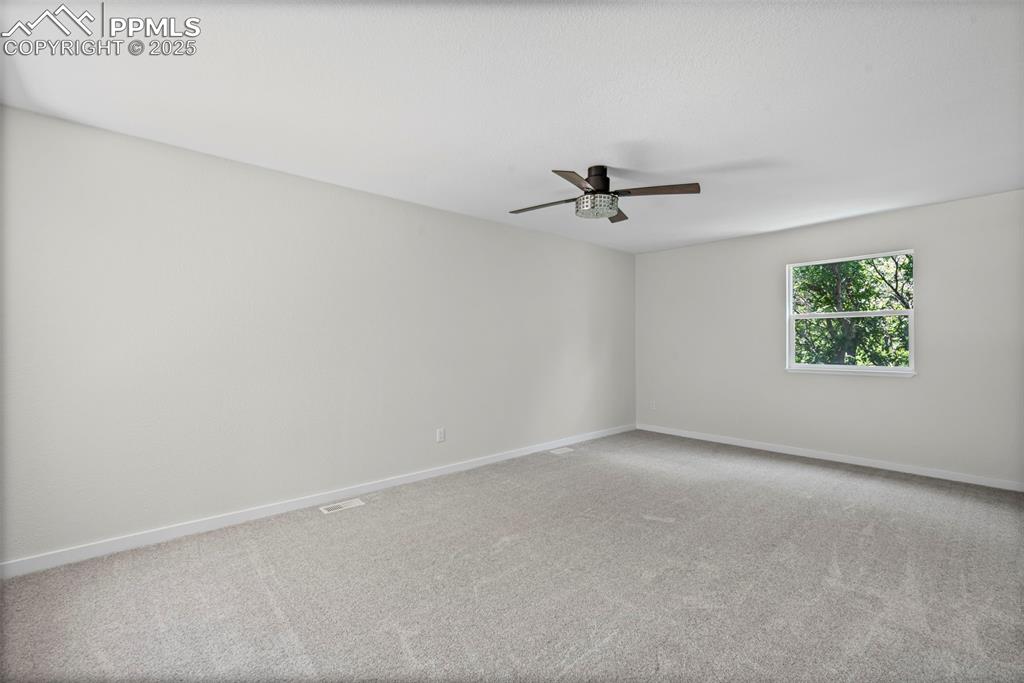 Image 21 of 48: Spare room featuring a ceiling fan and carpet flooring