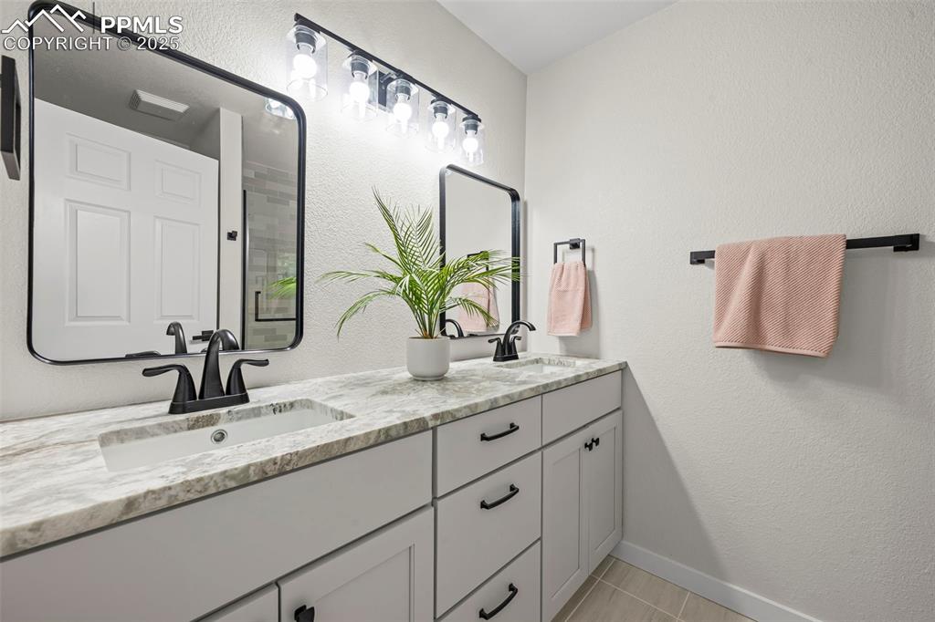 Image 24 of 48: Bathroom featuring double vanity and tile patterned flooring