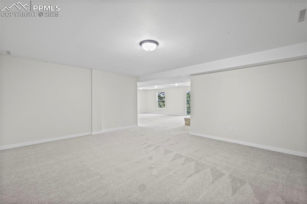 Image 28 of 48: Unfurnished room featuring carpet and a textured ceiling