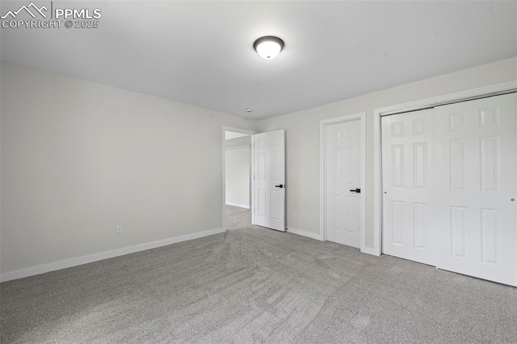 Image 32 of 48: Unfurnished bedroom with carpet flooring and baseboards