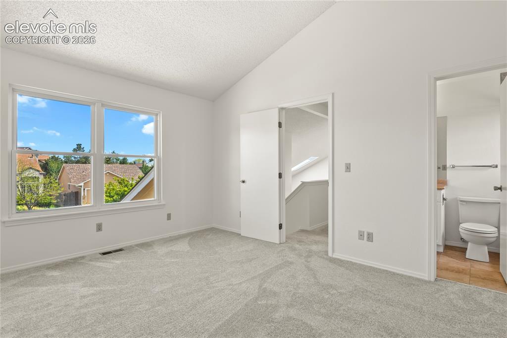 Image 20 of 33: Upper level bedroom with adjoining bath