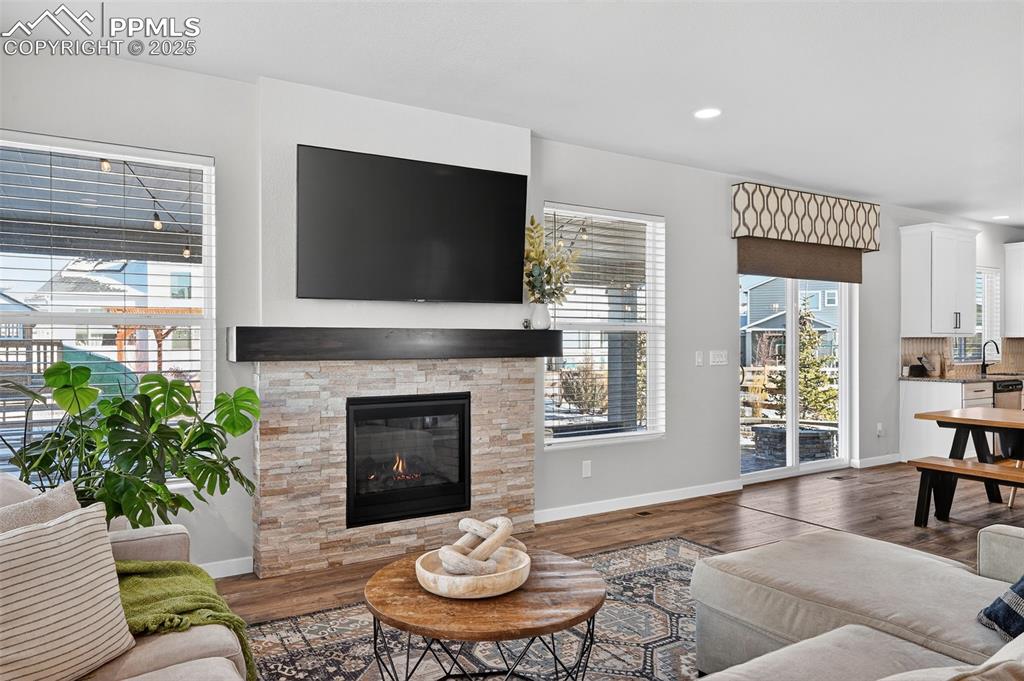 Image 12 of 43: Gas fireplace with stone and wood mantle