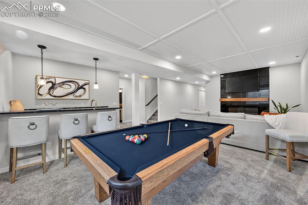 Image 30 of 43: Large basement rec room with gas fireplace