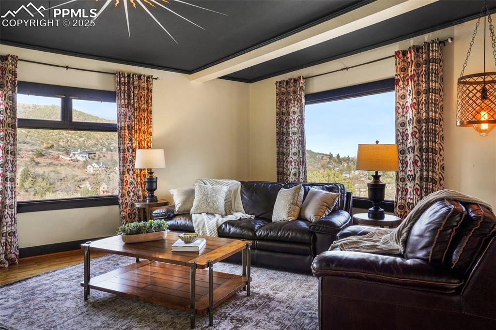 Image 14 of 47: Living area with a wealth of natural light, wood finished floors, and baseb
