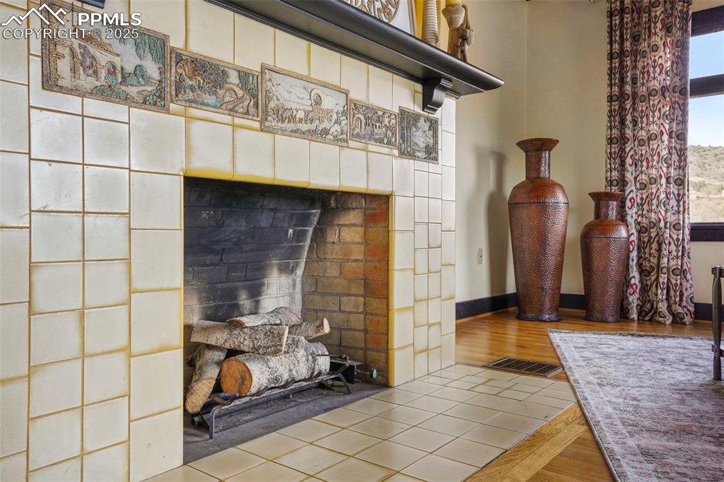 Image 17 of 47: Details featuring a Van Briggle tiled fireplace, visible vents, and wood fi
