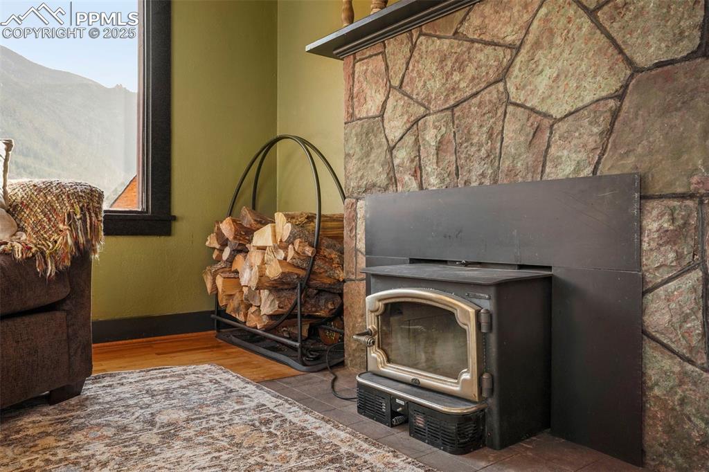 Image 20 of 47: Details featuring a wood stove framed in Manitou Green Stone 
and baseboar