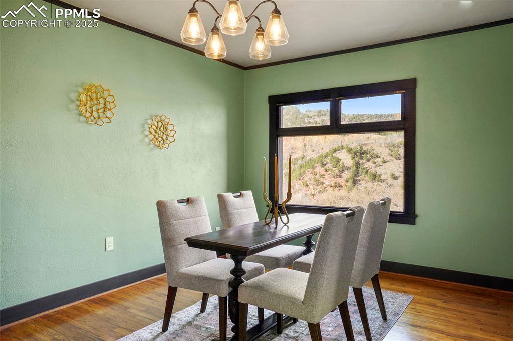 Image 21 of 47: Dining space with wood finished floors, an inviting chandelier, baseboards 