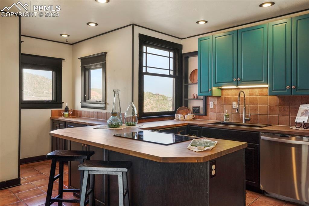 Image 27 of 47: Kitchen featuring stainless steel dishwasher, a sink, butcher block counter