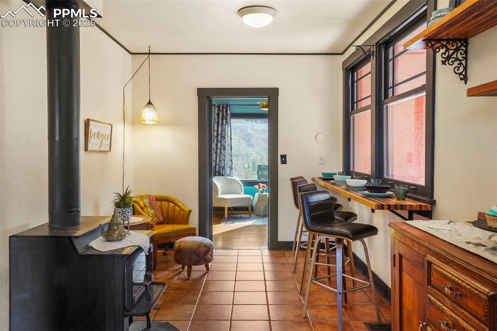 Image 29 of 47: Featuring a wood stove, tile floors, 4 seat breakfast bar with views of sid