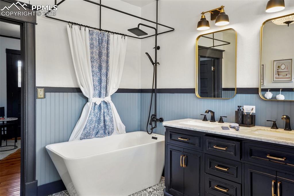 Image 41 of 47: Upper level full bathroom featuring a freestanding bath, double vanity, a s