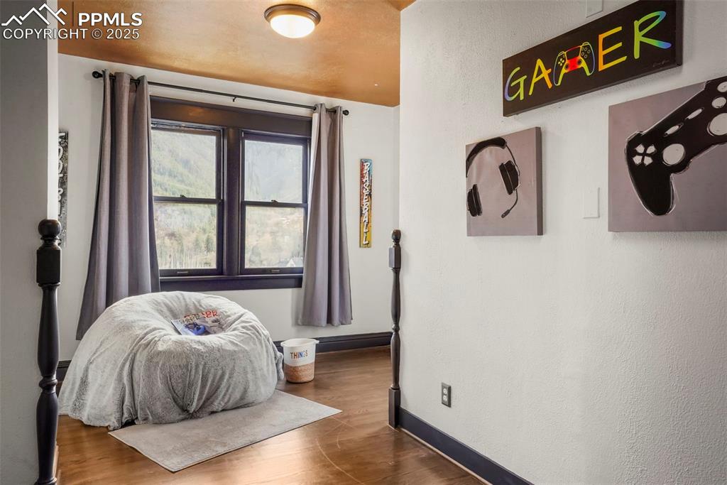 Image 46 of 47: 3rd upstairs bedroom with wood finished floors and baseboards
