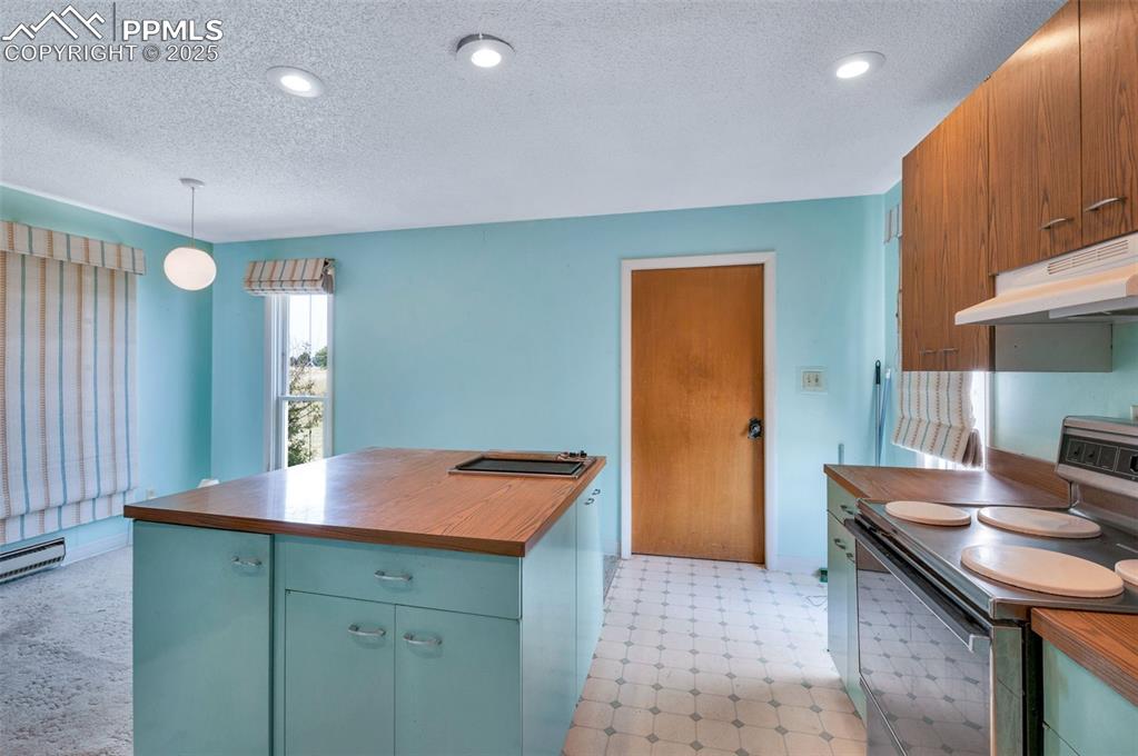 Image 15 of 50: Eating space is on the left, entrance to the garage on the back wall