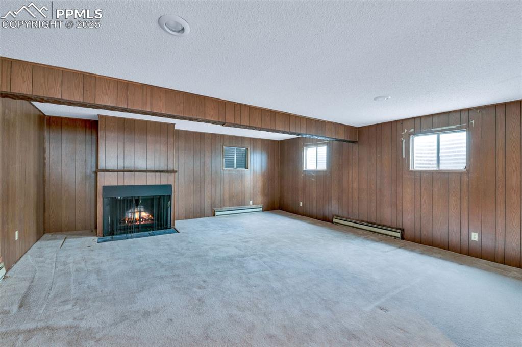 Image 35 of 50: Basement family room with a fireplace