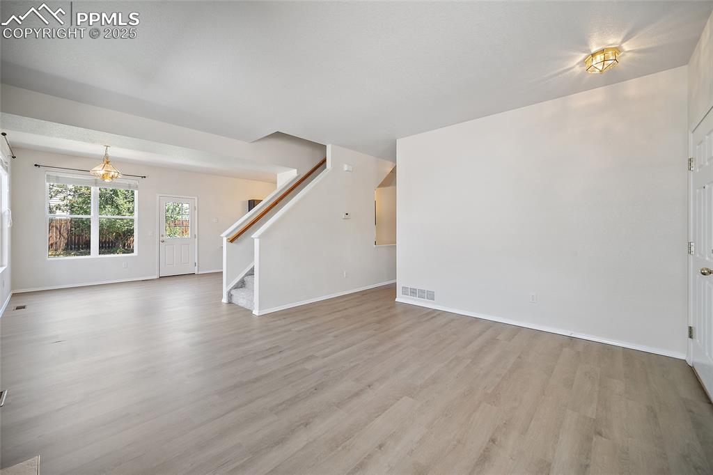 Image 8 of 46: A different angle of the living room and dining area. Hall is leading to Po