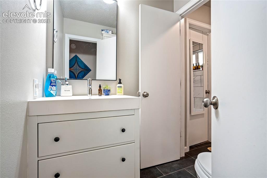 Image 39 of 50: White vanity with integrated sink, black rectangular mirror, and wall-mount