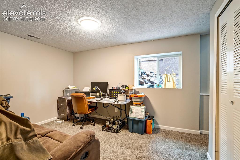 Image 43 of 50: Recessed lighting, neutral-toned walls, and a window well with natural rock