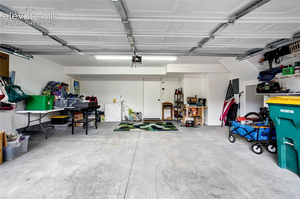 Image 50 of 50: Concrete flooring garage with white walls, white ceiling, and exposed garag